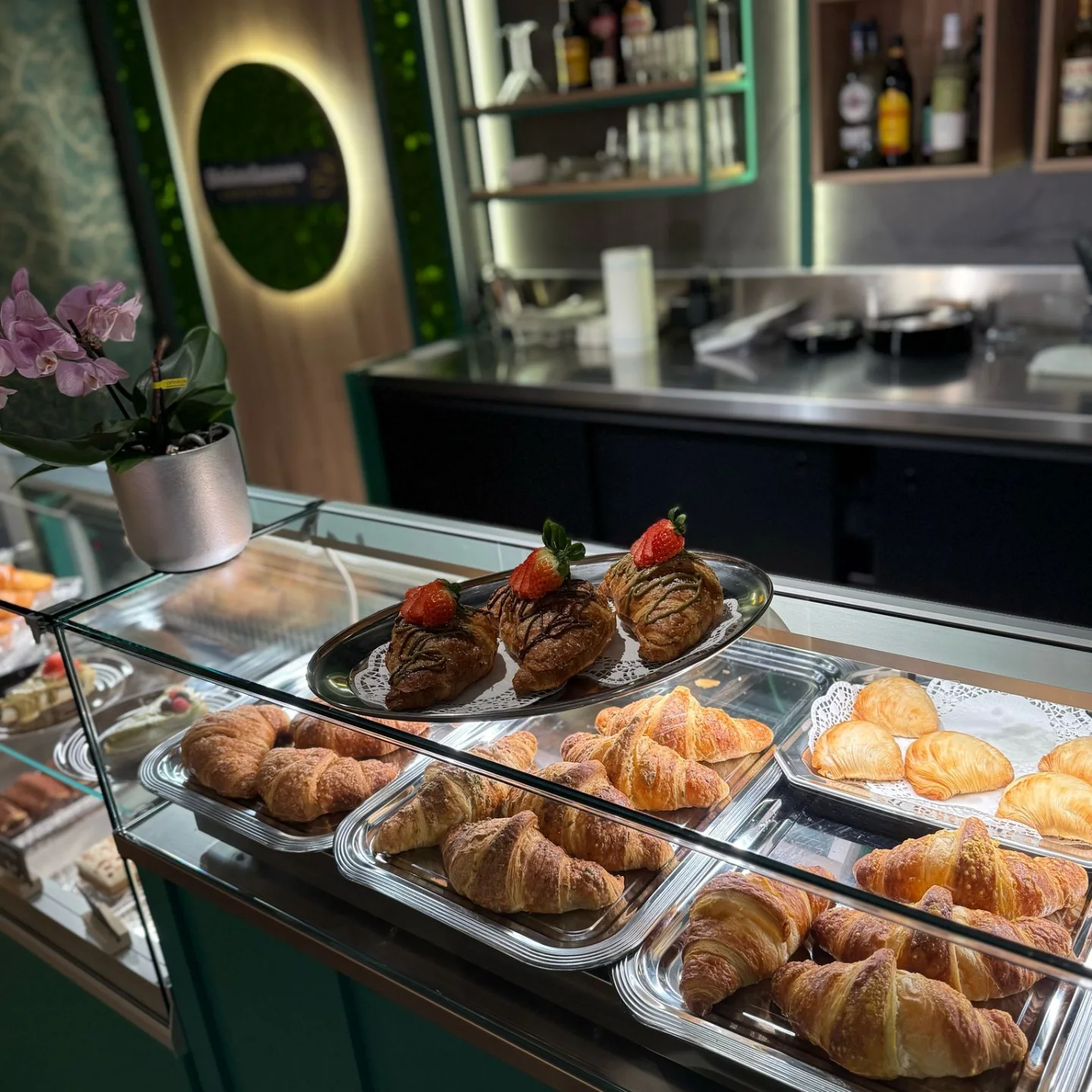 Glasvitrine mit Cornetti, Sfogliatelle und Cornetti mit Pistazienglasur und Erdbeere